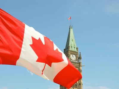 Centre Block on Parliament Hill and Canadian flag