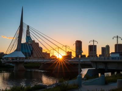 picture of the sunset sitting behind Winnipeg's skyline