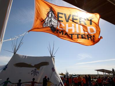 waving orange flag that says Every Child Matters