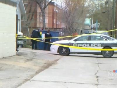 police tape and police officers in a Winnipeg backlane
